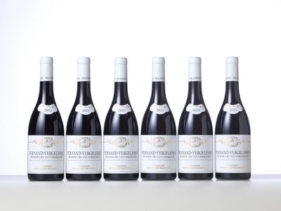 six bottles of wine are lined up on a table