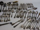 many spoons and forks laid out on the table