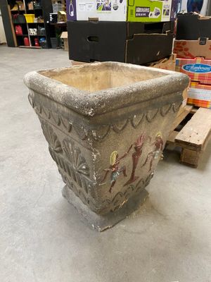 une jardinière posée à même le sol dans un entrepôt