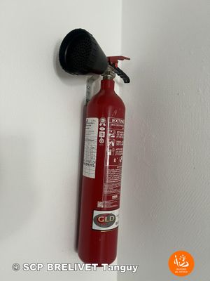 un extincteur rouge accroché au mur