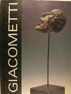 le livre est posé sur une table, à côté d'un vase en verre