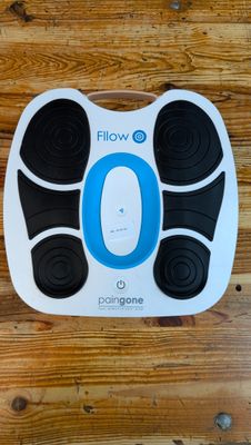 un appareil de massage des pieds électronique bleu et noir posé sur un parquet