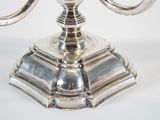 a silver candle holder with two candles on it