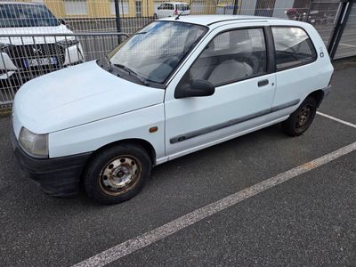 a small white car parked in a parking lot