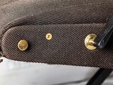a close up of a brown bag on a bed