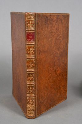 an old book sitting on top of a table next to a vase