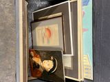 an open box with pictures and a cup inside of it