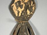 an old wooden sculpture of a person with a face and arms