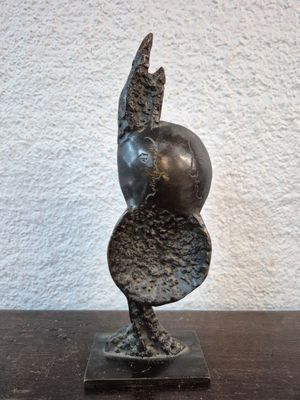 statue d'une femme tenant une balle sur une table en bois