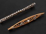 two antique silver and gold hair pins on a black background