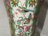 a vase with a bird on it sitting on a table