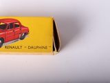 a small red toy car in a box on a white surface