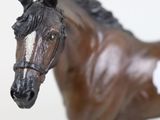 statue of a brown horse with a white tag on it ' s neck