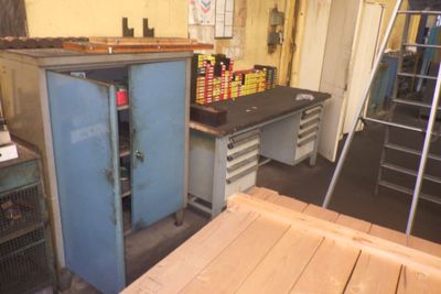une photo d'un espace de travail avec une armoire bleue et une échelle