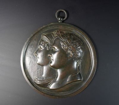 une image représentant une médaille d'argent sur laquelle figurent une femme et un homme