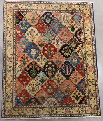 un tapis persan ancien présentant un motif multicolore sur fond blanc