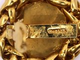 a close up of a gold bracelet with a chain around it