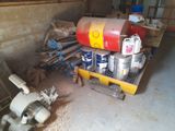 several cans of paint are stacked on top of a pallet in a garage