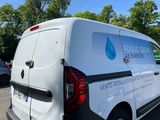 a van that is parked in a lot with trees in the background