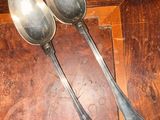 two spoons and a spoon rest on a wooden table