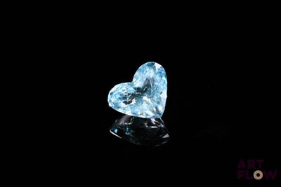 une topaze bleue en forme de cœur sertie de diamants sur un fond noir