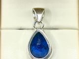 a close up of a pendant with a blue stone inside of it