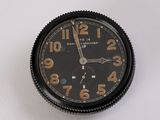 un gros plan d'une horloge noire posée sur une surface blanche