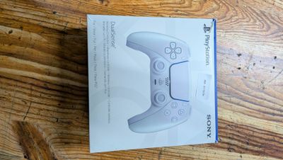 packaging of a white wii controller sitting on top of a wooden table