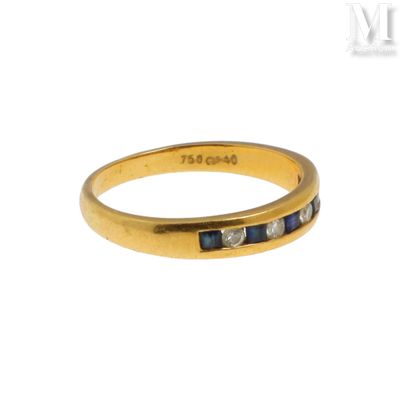 un gros plan d'une bague en or jaune sertie de pierres bleues et blanches