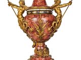 a red vase with angels on it on a white background