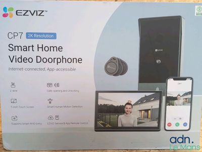 une image représentant une boîte sur laquelle figure une personne utilisant un téléphone portable et un interphone vidéo