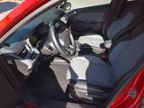 the interior of a red car with a steering wheel and dashboard