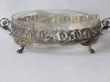 an antique silver plate with ornate design on it on a white surface