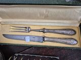 three knives and a fork in a box on a table