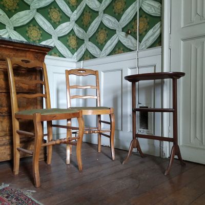 deux chaises et une table dans une pièce avec du papier peint
