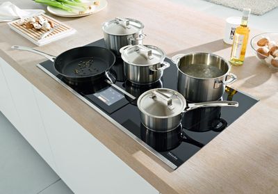 des casseroles et des poêles sont posées sur la plaque de cuisson dans une cuisine