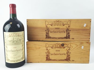 des bouteilles de vin rouge et une caisse en bois posées sur une surface blanche