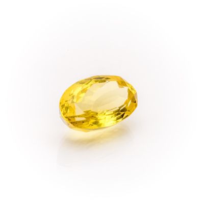 a yellow sapphire stone on a white background