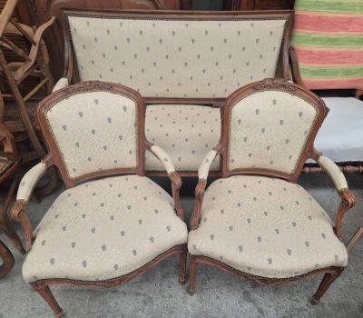 Trois fauteuils à accoudoirs rembourrés sont disposés dans une pièce