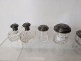 four salt and pepper shakers sitting on a glass table