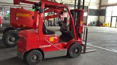 un chariot élévateur rouge garé dans un entrepôt