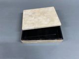 a small box with a black lid on a table