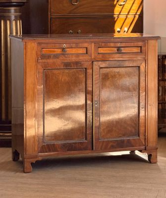 une armoire en bois dans une pièce, sur laquelle est posée une lampe
