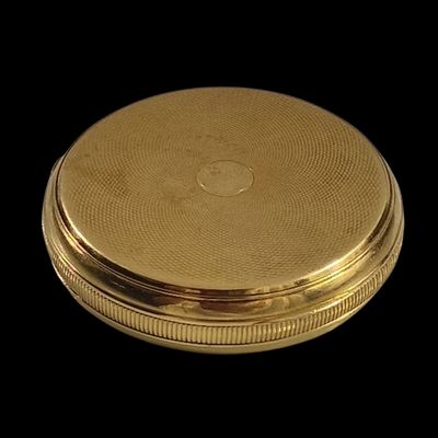 une image montrant un gros plan d'une assiette dorée sur fond noir