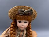 a doll that is wearing a straw hat and dress