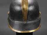 an antique helmet with a gold leaf on the top