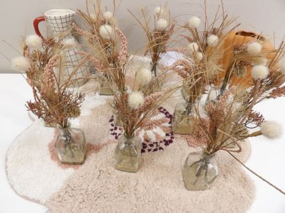 three vases with dried flowers in them sitting on a table