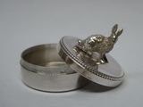 une petite boîte en argent sur laquelle est représenté un lapin