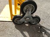 a wheel that is sitting on the ground next to a yellow pole