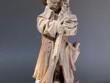 statue of a man holding a sword on a wooden base